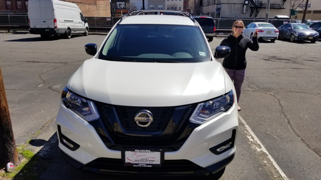 A woman standing next to a white car.