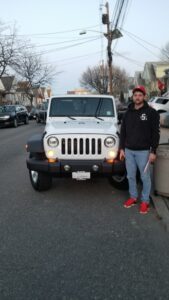A man standing next to a white jeep.